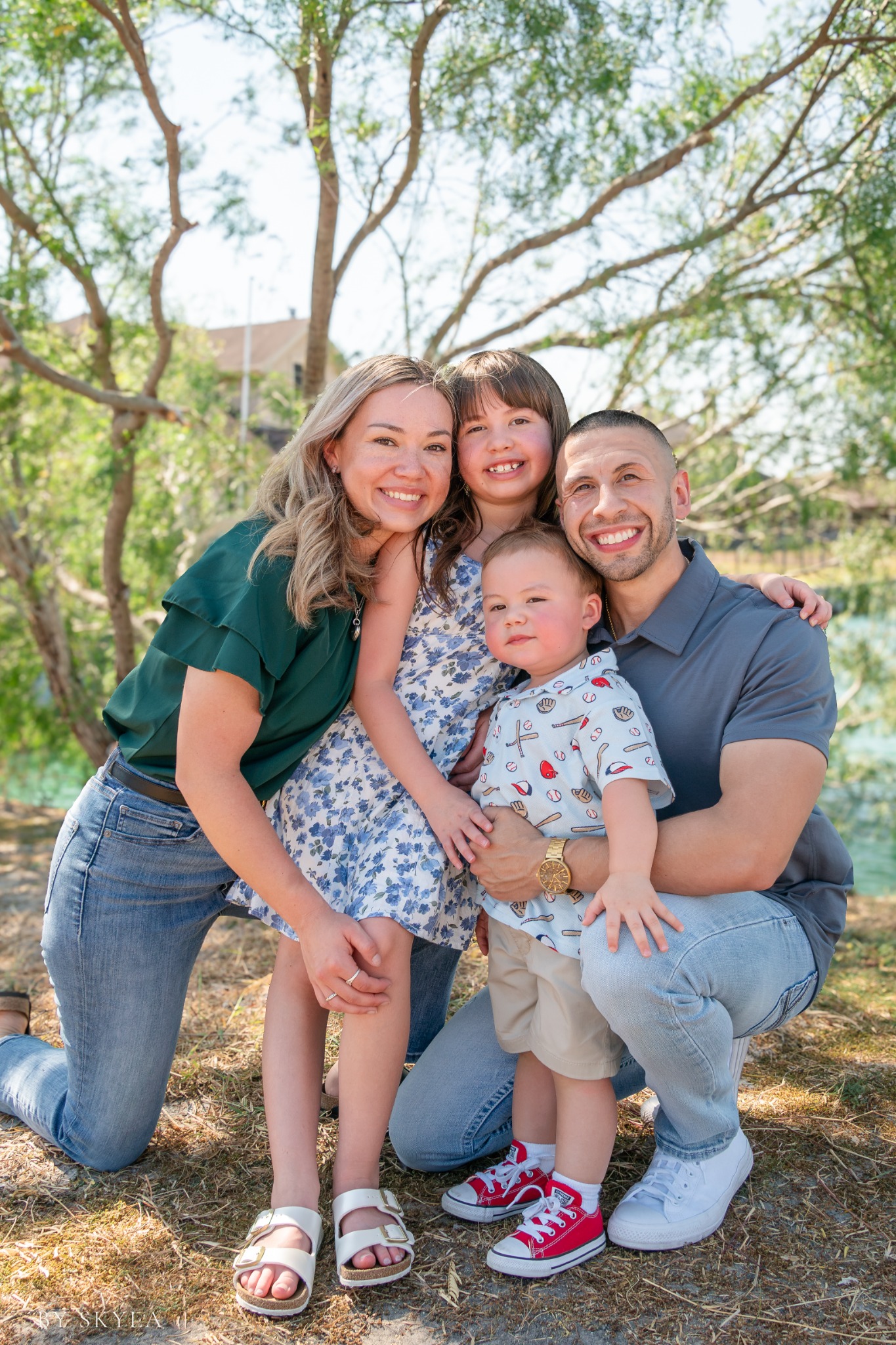 Family laughing together beside the water, from a previous By Skyla mini session
