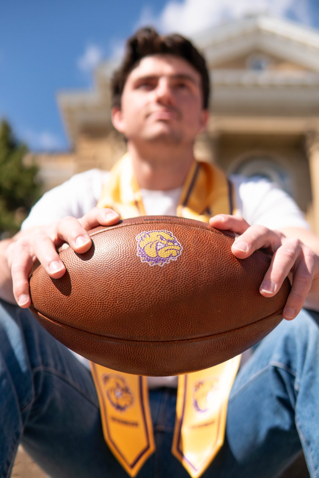 Graduating athlete holding a football