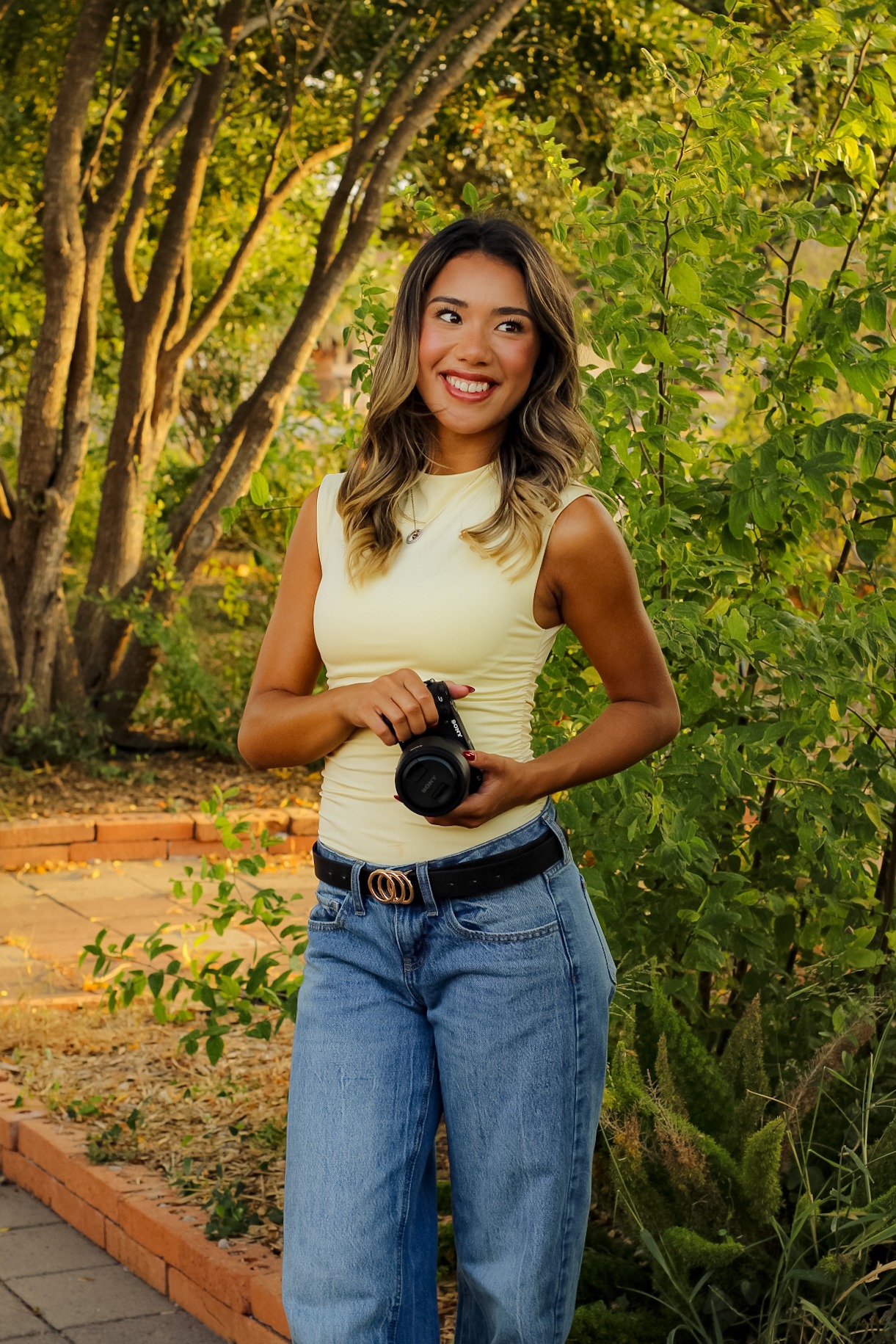 Mia of By Skyla holding her camera outdoors