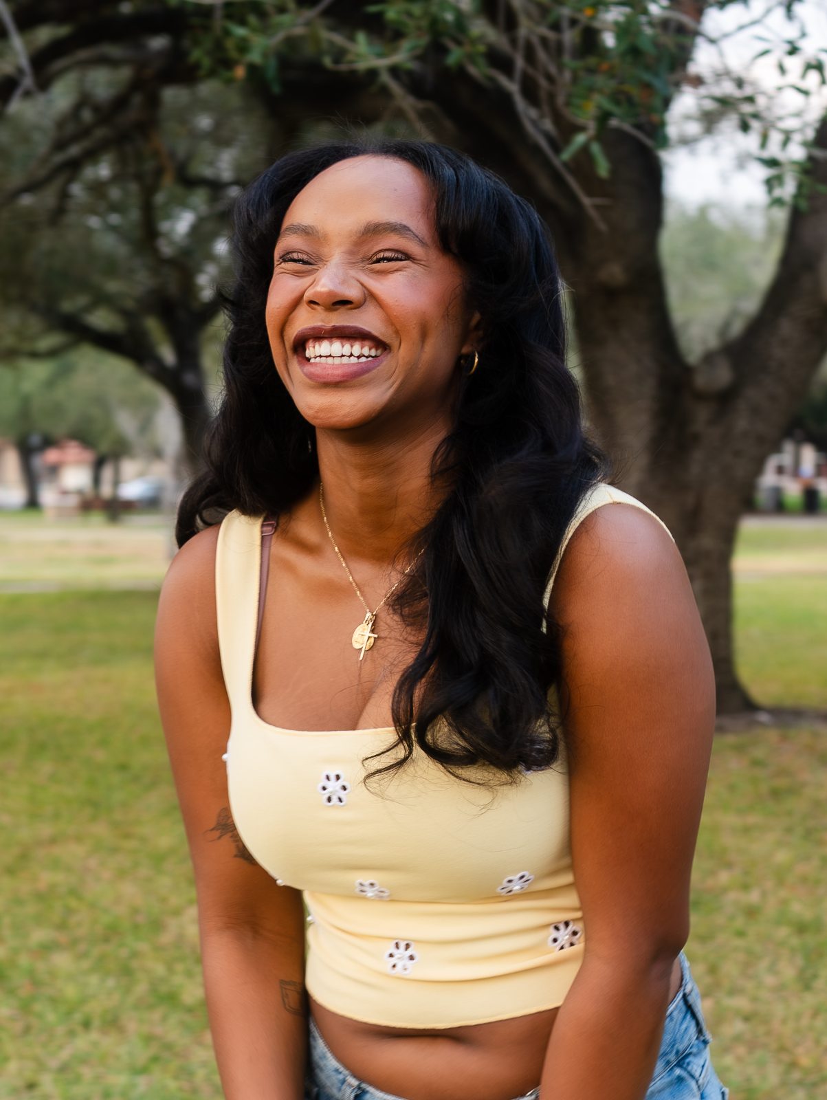 Portrait of a young woman laughing under a tree in Kingsville, Texas