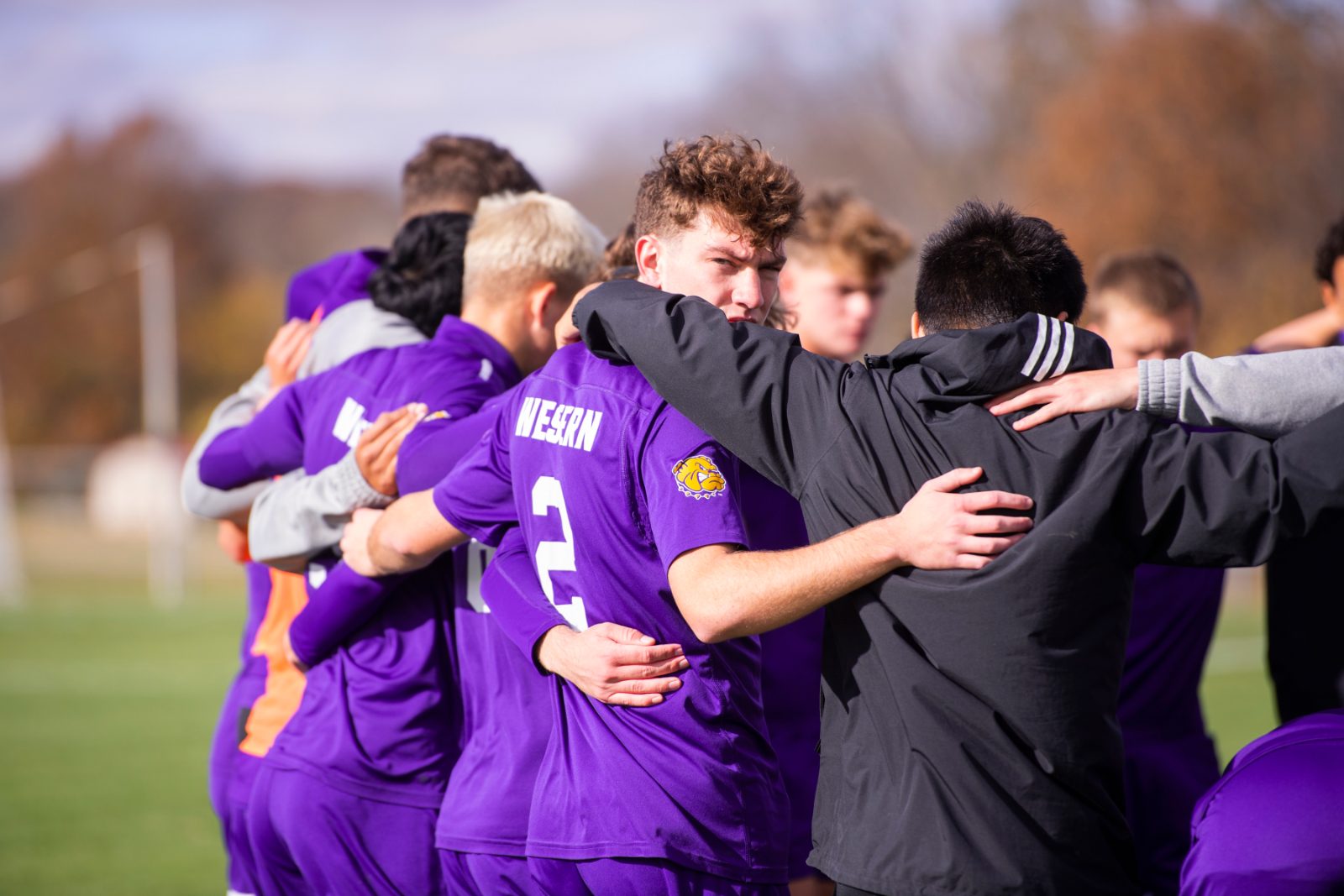Soccer team huddled together before kick-off